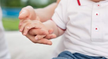 Close-up of mother holding child's hand