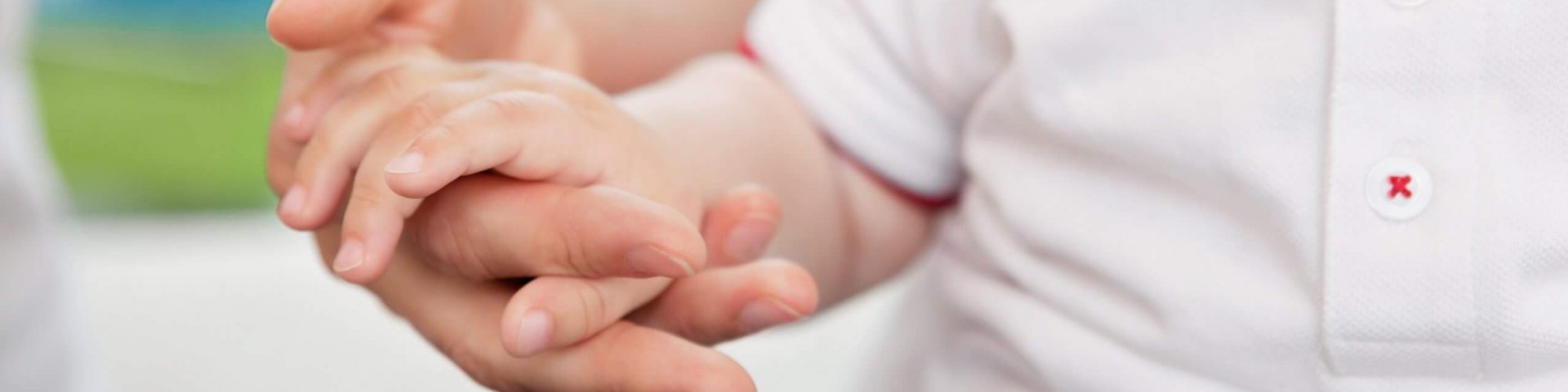 Close-up of mother holding child's hand